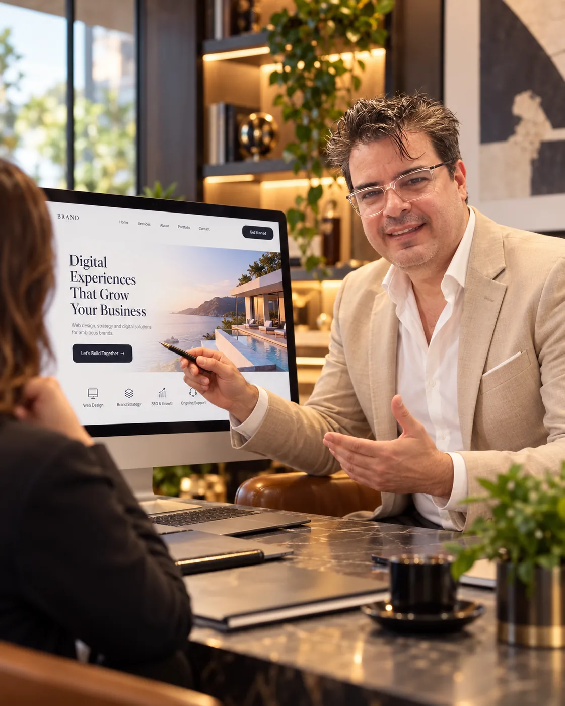 Elio Zambrano asesora a una clienta y le muestra el diseño de su nueva página web en un monitor